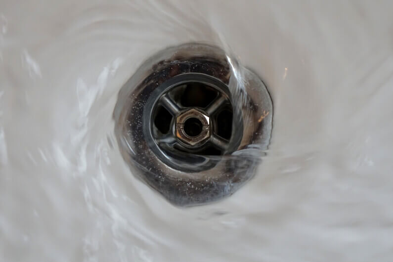 Photo of a drain emptying with swirling water